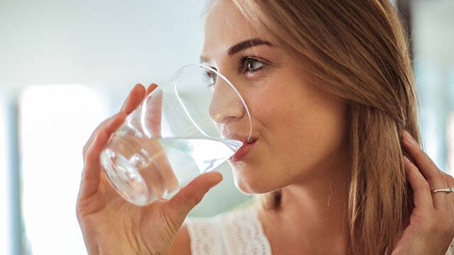 woman drinking water from glass cup woman drinking water from glass cup